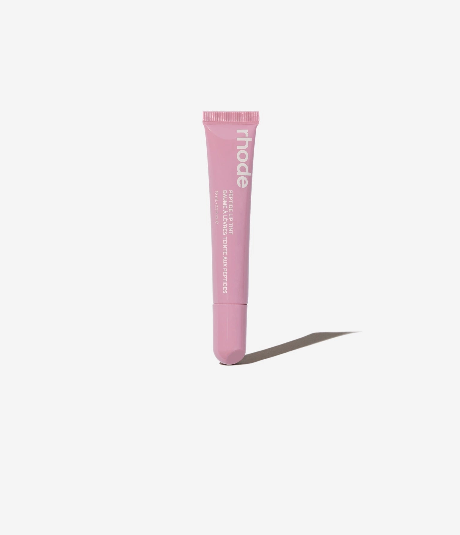 pink lip tint tube on a grey backdrop